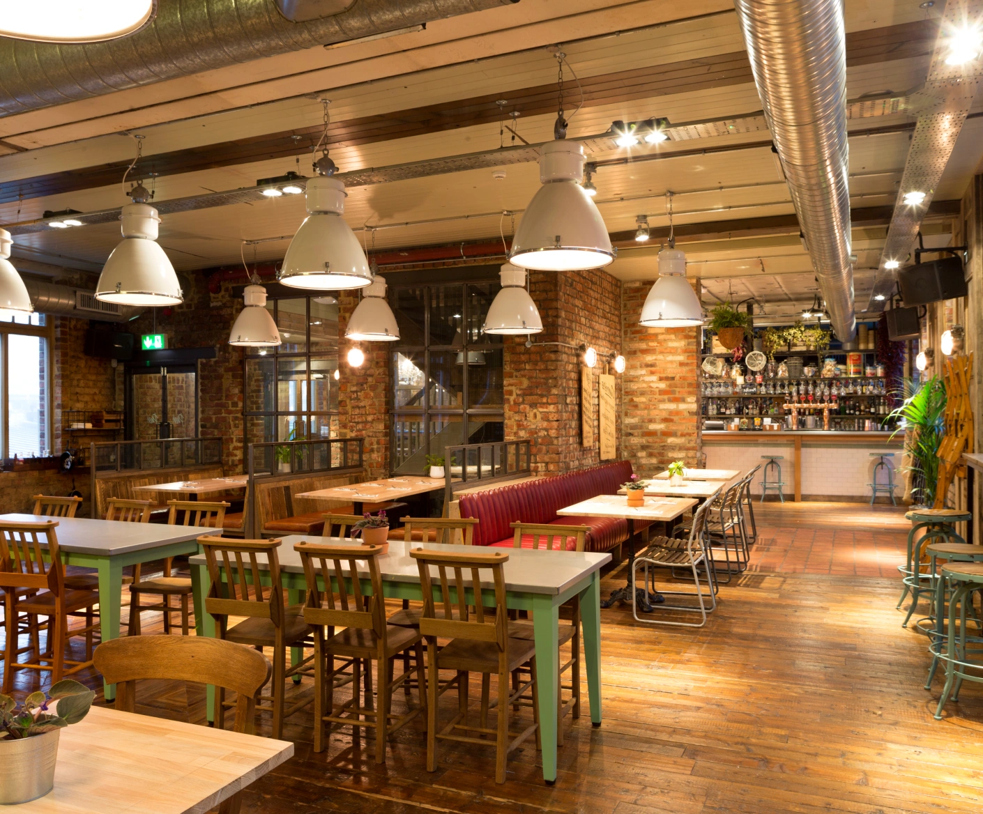 Industrial-chic restaurant interior with booths.